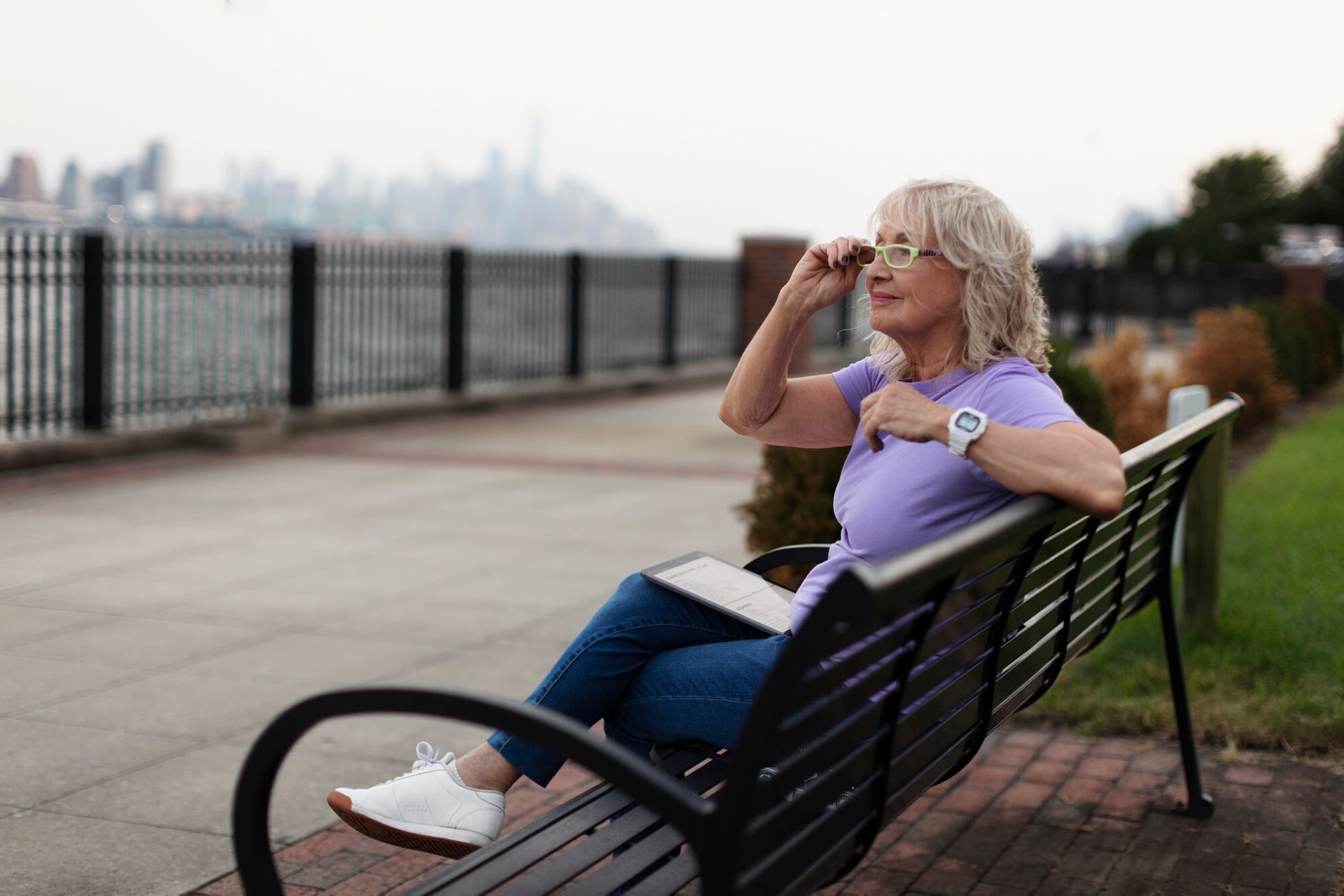 Persona adulta leyendo con comodidad junto a una ventana iluminada